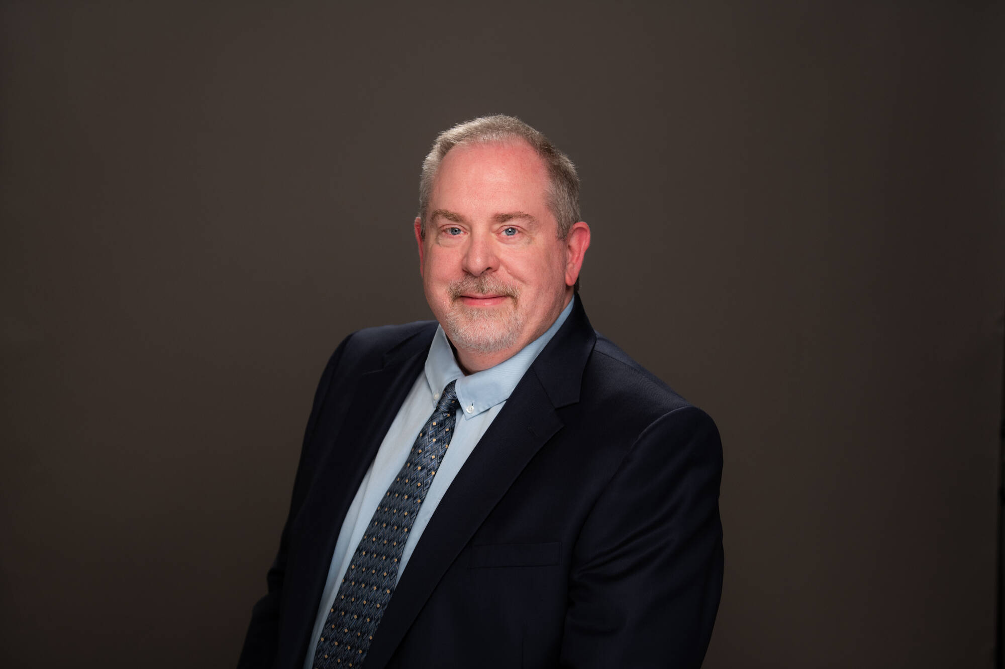 a man with blond hair and a goatee in a suit